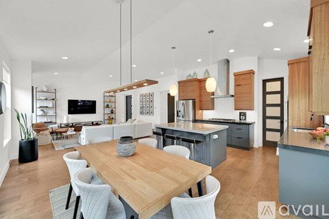 A modern kitchen with a wooden dining table and chairs.