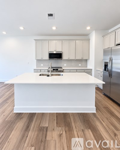 A kitchen with a white island and stainless steel appliances.