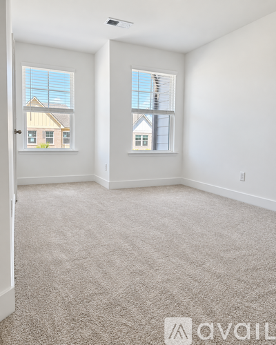 A room with two windows and a carpeted floor.