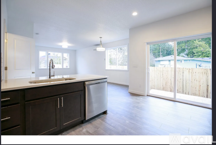 A kitchen with dark brown cabinets and a white countertop.