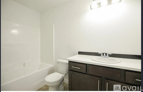A white toilet sits next to a sink in a bathroom.