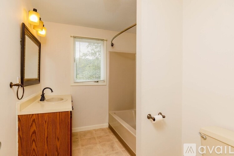 A bathroom with a sink, mirror, and bathtub.