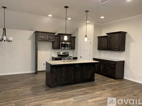 A modern kitchen with dark wood cabinets and a central island.