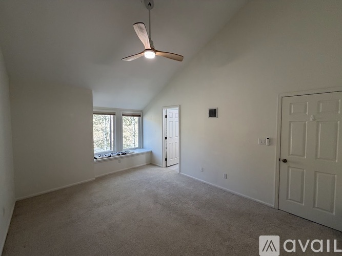 A room with a ceiling fan and a window.