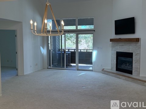 A living room with a fireplace and a television on the wall.