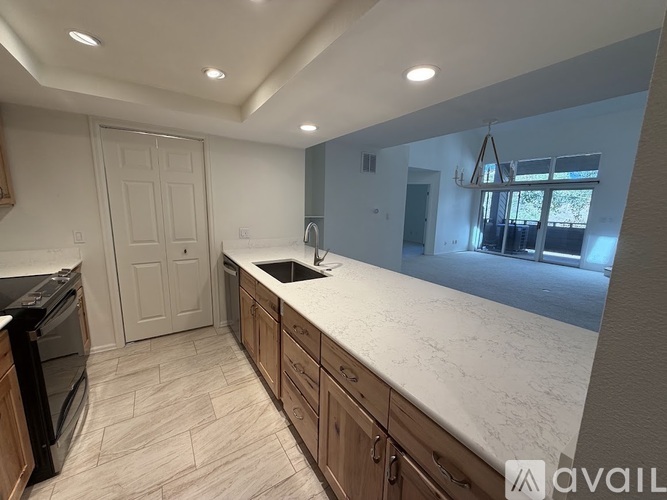 A kitchen with a black oven and wooden cabinets.
