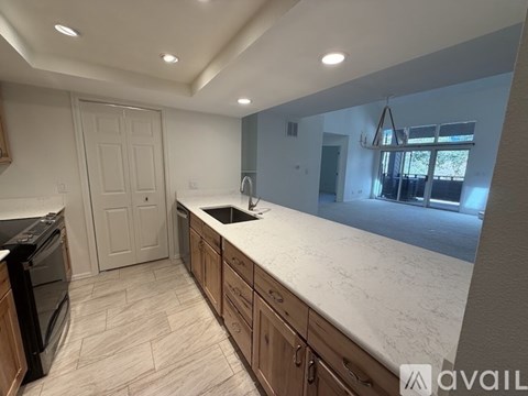 A kitchen with a black oven and wooden cabinets.