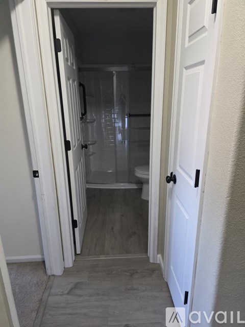 A white door is open to a bathroom with a toilet and sink.