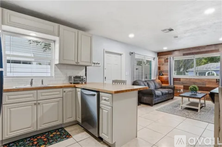 A kitchen with white cabinets and a black fridge.