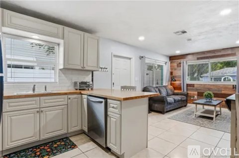 A kitchen with white cabinets and a black fridge.