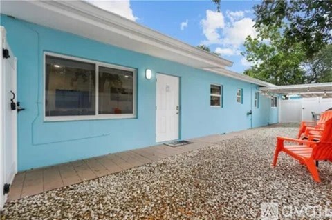 A blue house with a red chair in front.