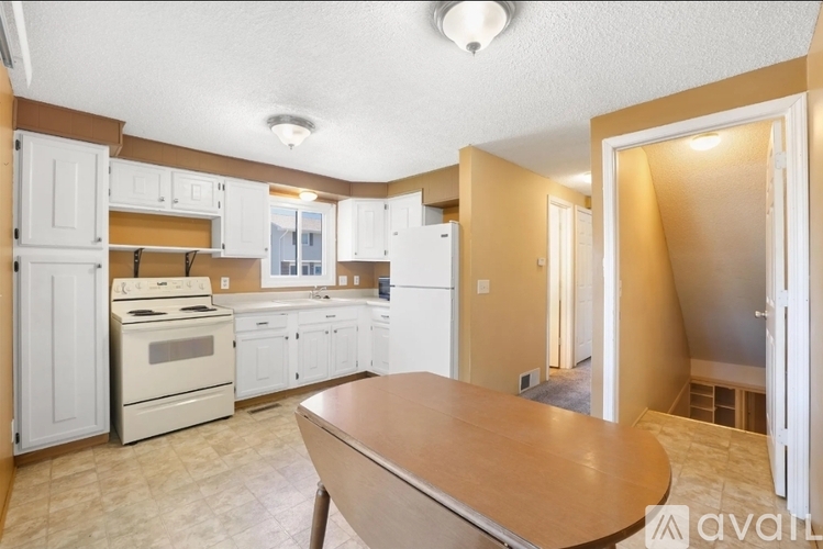 A kitchen with a table and chairs in the middle of the room.