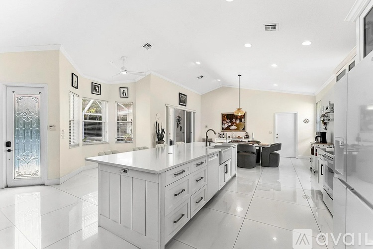 A modern kitchen with white cabinets and appliances.