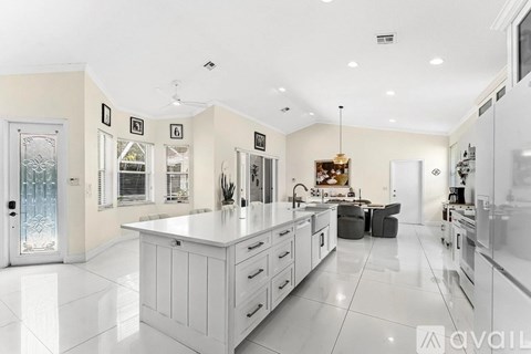 A modern kitchen with white cabinets and appliances.