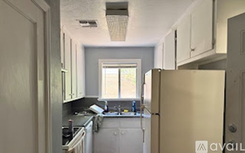 A kitchen with white cabinets and a window.