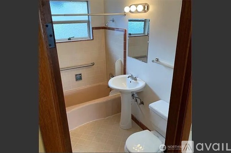 A bathroom with a toilet, sink, and shower.