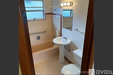 A bathroom with a toilet, sink, and shower.