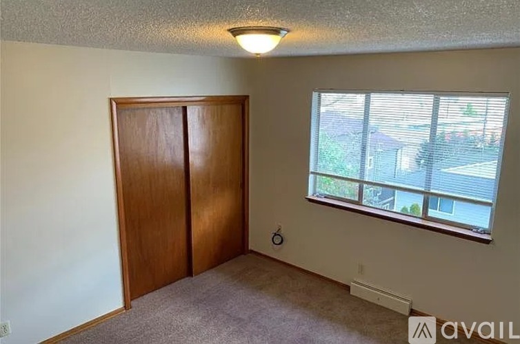 A room with a brown door and a window with blinds.