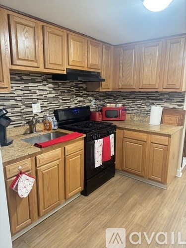 A kitchen with wooden cabinets and a black stove top oven.
