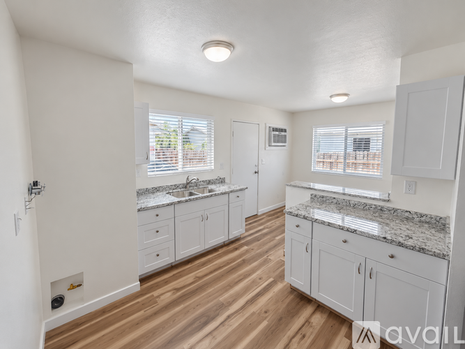 A kitchen with white cabinets and a granite countertop.