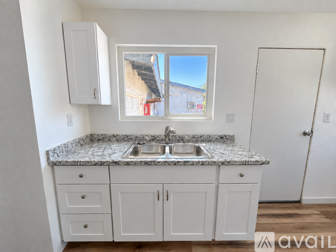 A kitchen with a marble countertop and white cabinets.
