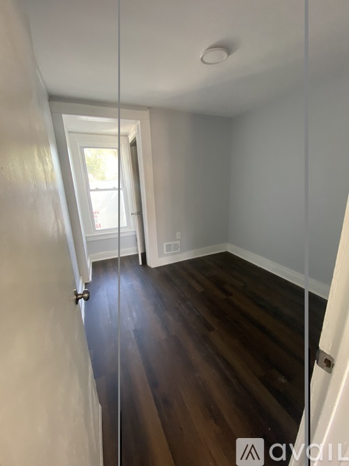 A hallway with wood floors and white walls.