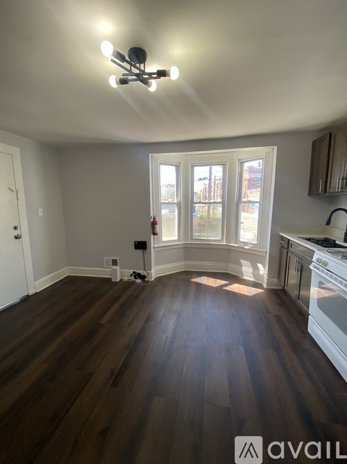A kitchen with a wooden floor and a white ceiling.