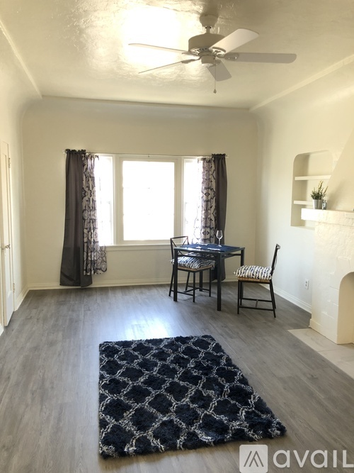A room with a table and chairs by a window.