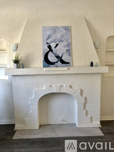 A white fireplace with a painting above it.
