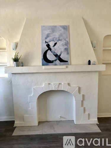 A white fireplace with a painting above it.