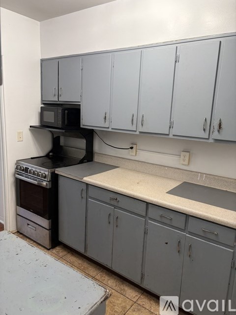 A kitchen with a stove, oven, and cabinets.