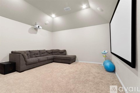 A living room with a grey sofa and a blue ball.