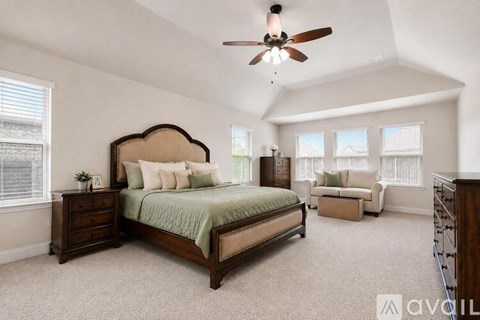 A bedroom with a large bed, a dresser, and a window with blinds.