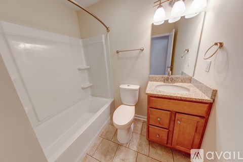 A bathroom with a toilet, sink, and mirror.