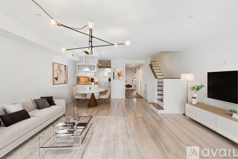 A modern living room with a white sofa and a glass coffee table.