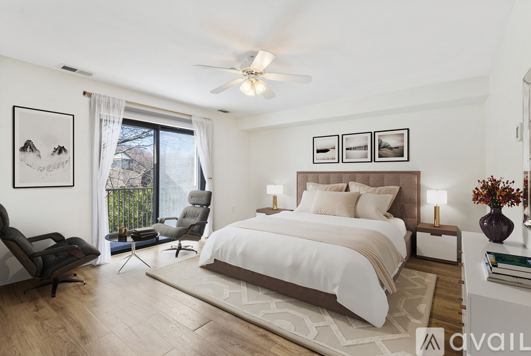 A bedroom with a large bed, a chair, and a ceiling fan.
