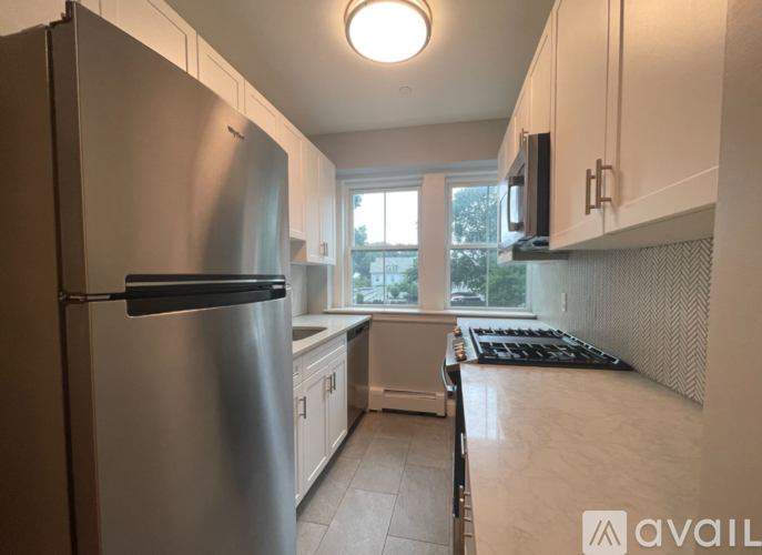 A kitchen with a stainless steel refrigerator and a white countertop.
