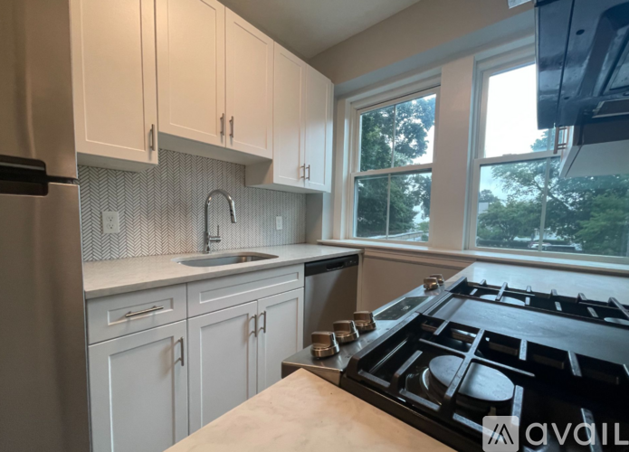 A kitchen with white cabinets and a black stove top.
