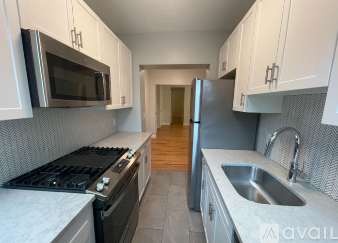 A kitchen with a stove, sink, and refrigerator.