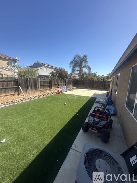A backyard with a lawn and a toy car.