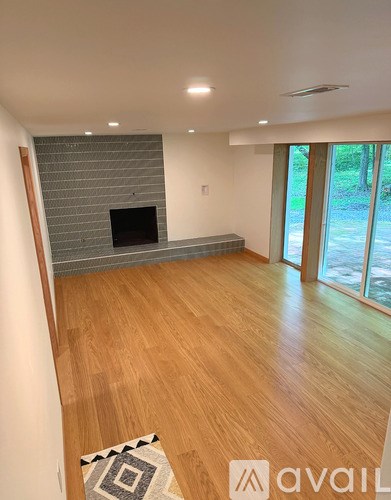 A living room with a fireplace and wooden floors.