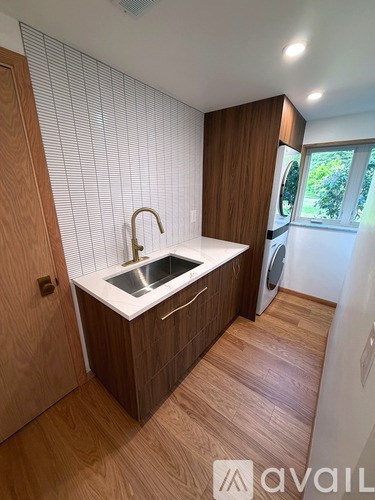 A modern kitchen with wooden cabinets and a white countertop.