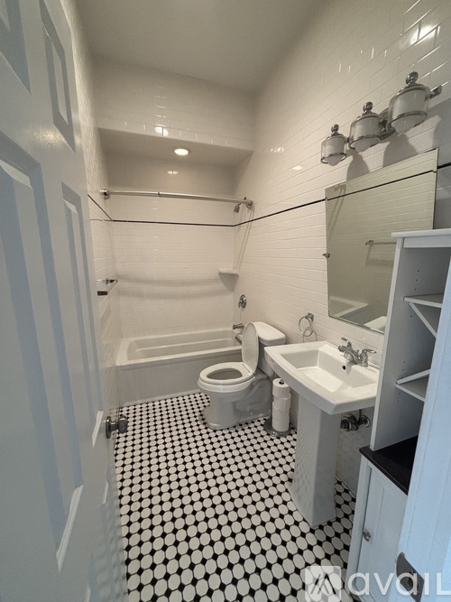A white bathroom with a black and white floor.