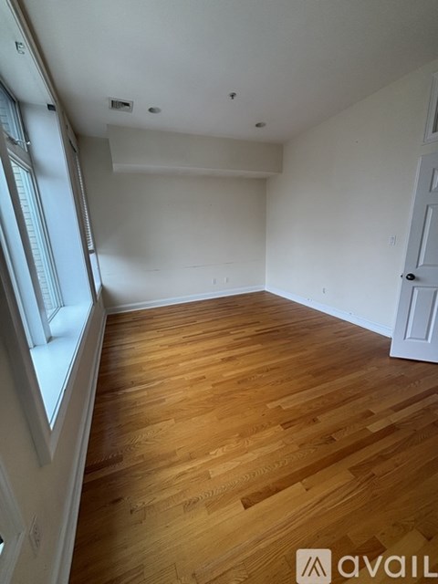 A room with wooden flooring and white walls.