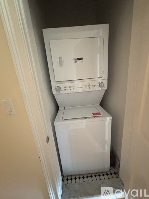A white washing machine in a small laundry room.