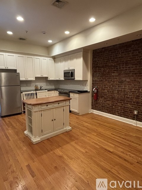 A kitchen with wooden floors and white cabinets.