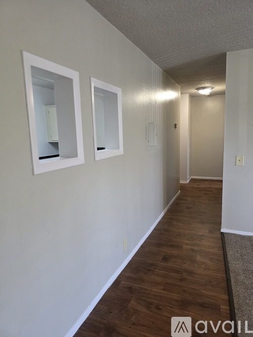 A hallway with wood floors and white walls.