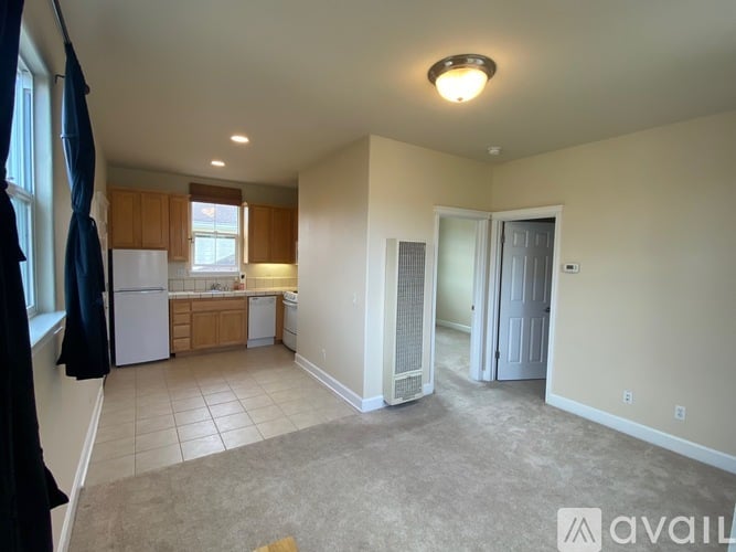 A living room with a kitchen in the background.