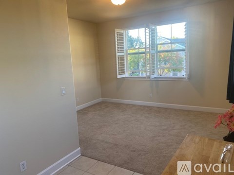 A room with a window and a carpet on the floor.