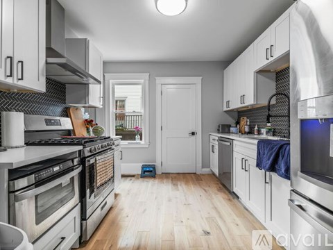 A kitchen with white cabinets and a wooden floor.